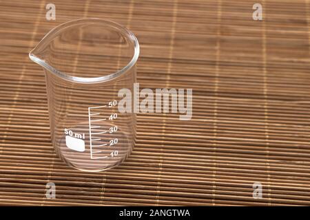 Un verre vide 50 ml Bécher sur une surface en bois Banque D'Images