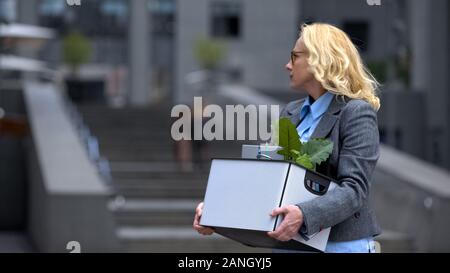 Femme âgée avec plein de trucs fort quitter office building, l'âge de la retraite, possibilité de travail Banque D'Images