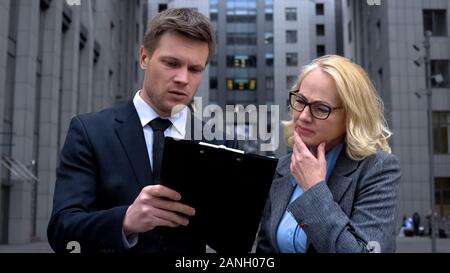 Insatisfait femme directrice de lecture du rapport de l'employé, les modalités du contrat discussion Banque D'Images