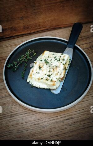 Recette végétarienne de halloumi au miel et thym sur une plaque avec un couteau Banque D'Images