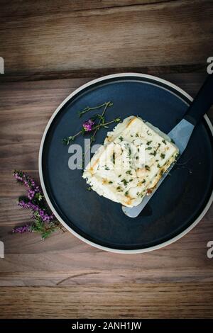 Recette végétarienne de halloumi au miel et thym sur une plaque avec un couteau Banque D'Images