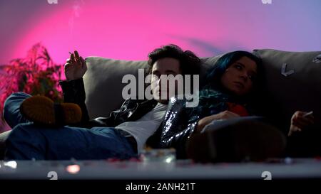 Deux toxicomanes avec des cigarettes détente sur coach, SIDA publicité sociale Banque D'Images