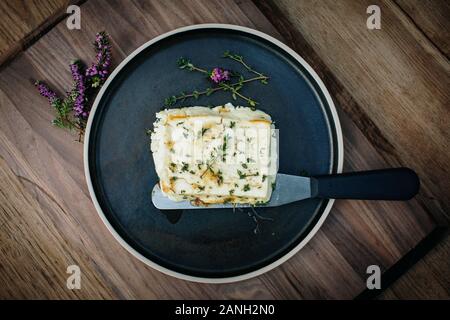 Recette végétarienne de halloumi au miel et thym sur une plaque avec un couteau Banque D'Images