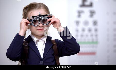 Lycéenne mettant d'essai optique afin de déterminer l'acuité visuelle, optométriste Banque D'Images