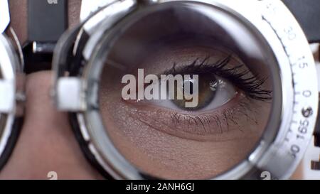 Close-up female eye dans le cadre d'essai optique, objectif de sélection, contrôle vision Banque D'Images