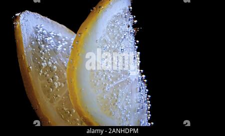 Citruse citron dans l'eau avec des bulles d'air Banque D'Images