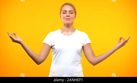 Femme détendue méditant sur fond lumineux, techniques du yoga, concentration Banque D'Images