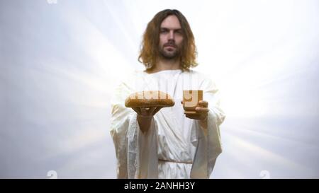 Jésus Pain et vin holding sur fond lumineux, cérémonie chrétienne Banque D'Images