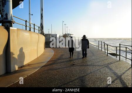 Couple en train de marcher le long du front de Cleveleys par un beau jour en hiver après une tempête avait juste après Banque D'Images