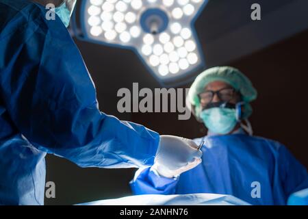 Médecin de l'équipe de chirurgie dans la salle d'opération de la césarienne abdominale lors de l'accouchement à l'hôpital d'urgence infirmière du patient. Banque D'Images