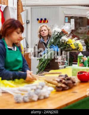 Deux fleuristes, travailler dans une pépinière. Couple travail dans l'entreprise de jardinage sur une journée de travail ordinaire. Sur la photo une femme blonde et une jeune femme avec r Banque D'Images
