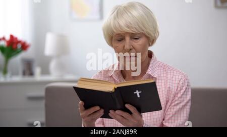 Senior woman reading religieux sainte bible à la maison, foi et croyance concept Banque D'Images