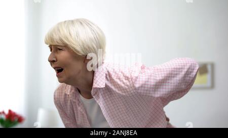 De dame holding back sensation forte douleur, problème de santé vertébrale au cours de la vieillesse Banque D'Images