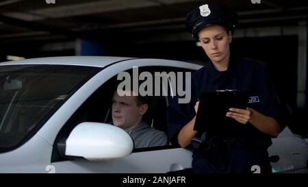 Femme officier écrit traffic ticket de conducteur pour une contravention, amende Banque D'Images