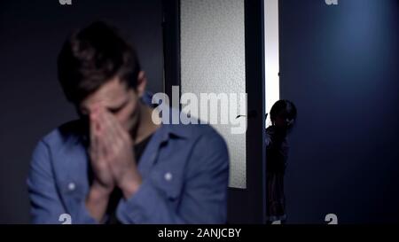 Père déprimé pleurer dans chambre, petite fille de l'ouverture de la porte, la douleur de la perte Banque D'Images