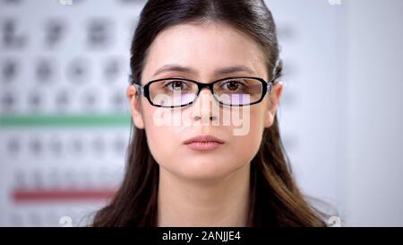 Femelle avec vision trouble mise sur des verres de lunettes, choix approprié Banque D'Images