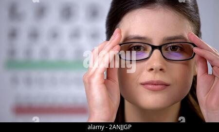 Dame avec vision trouble mise sur des verres, des soins de santé, d'amélioration de la vision Banque D'Images