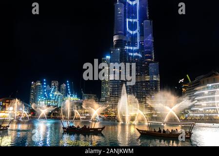 La fontaine de Dubaï afficher éclairés la nuit avec des bateaux d'excursion en face de chorégraphié des fontaines dans le lac Burj Khalifa, DUBAÏ, ÉMIRATS ARABES UNIS Banque D'Images