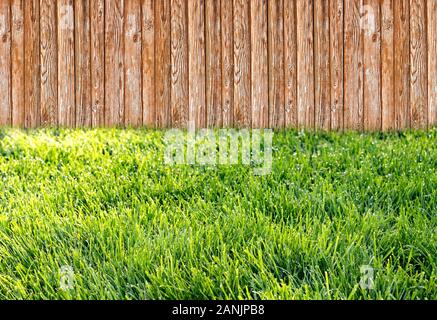 Clôture de jardin en bois au jardin avec l'herbe verte Banque D'Images