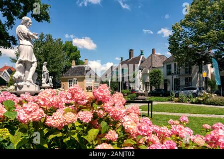 Zaandijk, un village typique et authentique avec d'agréables maisons et un petit jardin avec de belles statuen public plantes fleuries Banque D'Images