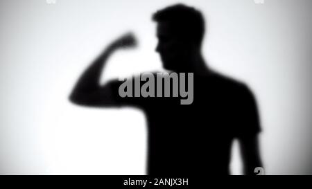 Silhouette d'homme confiant montrant des biceps, bodybuilding et fitness, close-up Banque D'Images