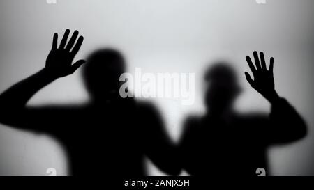 Silhouettes à peine respirer derrière un mur de verre, mourir d'une attaque chimique Banque D'Images