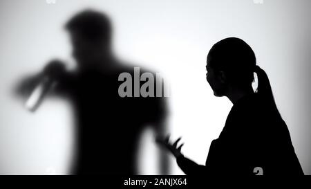 Silhouette de femme criant sur mari ivre à travers le verre, des problèmes d'alcool Banque D'Images