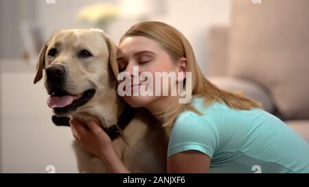 Jeune femme hugging adorable labrador chien, housepet, meilleur ami concept Banque D'Images