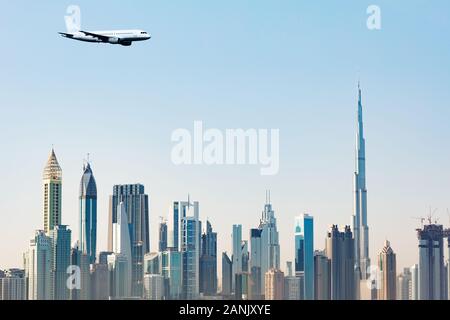 Avion de voler au-dessus de Dubaï moderne des gratte-ciel contre Ciel Bleu clair Banque D'Images