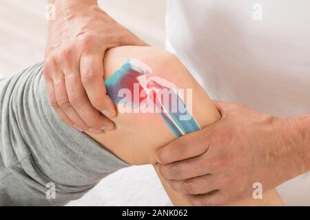Close-up de thérapeute de massage du genou faisant main Banque D'Images