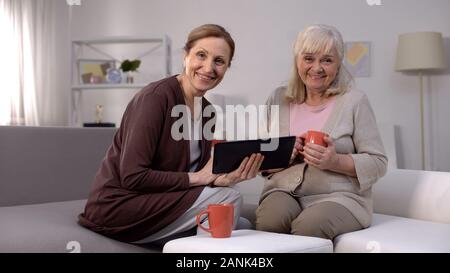 Les femmes âgées smiling holding tablet app, les services bancaires en ligne, connexion à internet Banque D'Images
