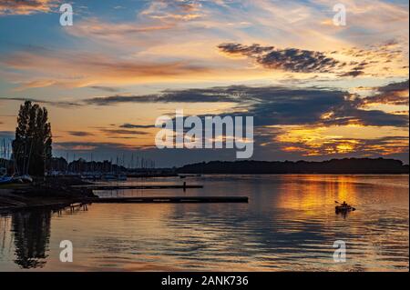 Les canoéistes dans le coucher du soleil, Chicester harbour, Angleterre Banque D'Images