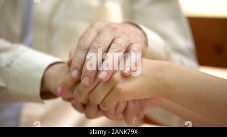 Senior man holding main de jeune femme, soutien et soins de concept relatif Banque D'Images
