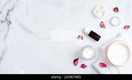 Natural spa bio huile corps, crème, éponge luffa et tour de table en marbre avec des pétales de rose. Soins du corps, nettoyer la peau, SPA concept. Banque D'Images