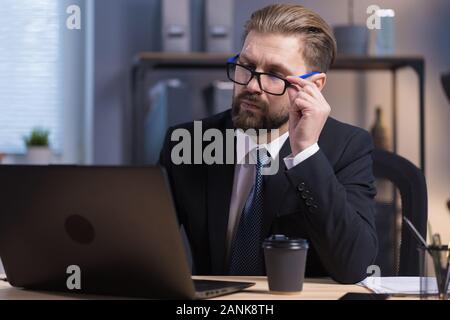 Barbu réfléchis soigneusement en col blanc l'examen des données Banque D'Images