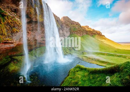 Vue parfaite de la célèbre cascade de Seljalandsfoss puissant dans la lumière du soleil. Scène magnifique et spectaculaire. Attraction touristique populaire. Emplacement Placez l'Islande, Banque D'Images