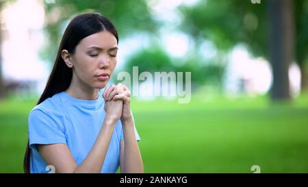Femme asiatique en plein air joindre les mains en prière, de croyances religieuses, de demander de l'aide Banque D'Images
