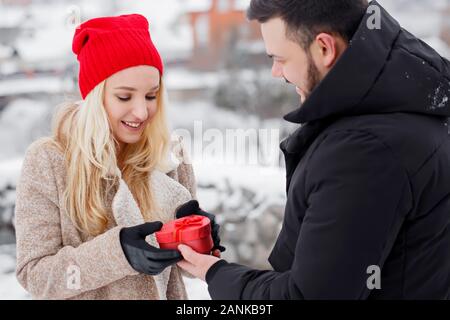 Un gars donne sa petite amie une boîte en forme de cœur, un concept pour la Saint-Valentin Banque D'Images