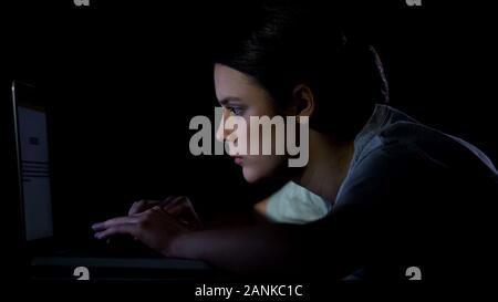 Student girl typing on laptop la nuit, travaillant sur le projet de diplôme, bourreau de travail Banque D'Images