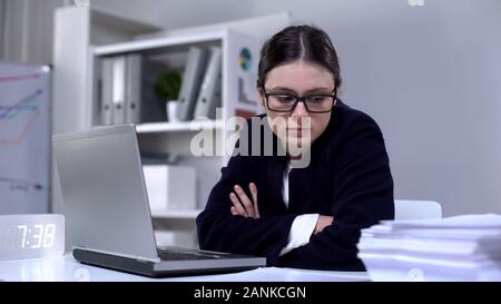 Femme en colère en tailleur à la pile de documents à, submergé de travail Banque D'Images