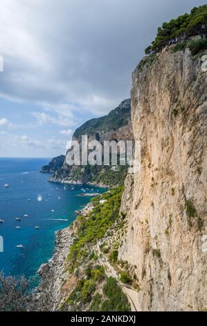 Photo verticale de rochers et falaises de l'île de Capri. Au point de vue mer baie avec de petites embarcations du local et parfaite des murs de grimpe. Capri, Italie. Banque D'Images