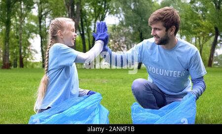 Fille bénévole masculin et la collecte des déchets, la forêt des cinq Banque D'Images