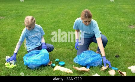 Lycéenne et mère de recueillir les ordures dans la pollution de la terre, du parc, de l'écosystème Banque D'Images