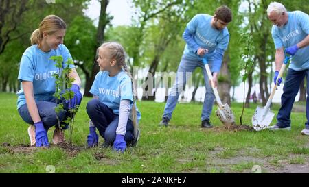 Éco volontaires travaillant au parc de la ville, la plantation d'arbres, les soins et la protection de la nature Banque D'Images