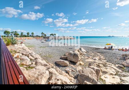 Les familles et les touristes apprécient un après-midi ensoleillé sur la Côte d'Azur à la plage de Fossan de Menton, France. Banque D'Images