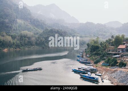 En laotien traditionnel bateau lent sur la rivière Nam Ou près du village de Nong Khiaw, Laos. Reflet dans l'eau Banque D'Images