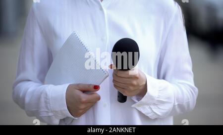 Femme journaliste holding notebook et microphone, la préparation pour l'entrevue Banque D'Images