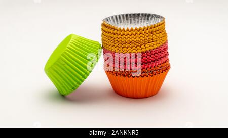 Arc-en-ciel de cupcake wrappers colorés empilés à l'envers sur un fond blanc Banque D'Images