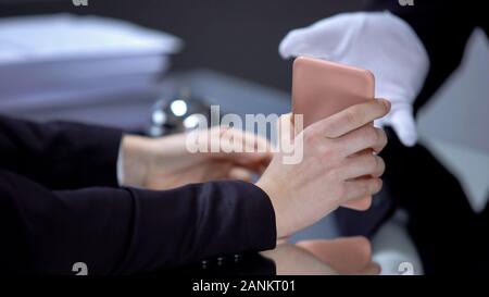 Femme anxieux de se quereller avec hôtel réceptionniste, montrant le téléphone, écart Banque D'Images