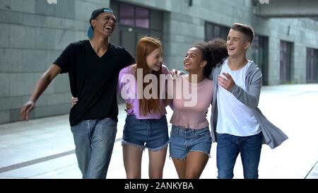 Smiling university students hugging walking street, happy friends having fun Banque D'Images